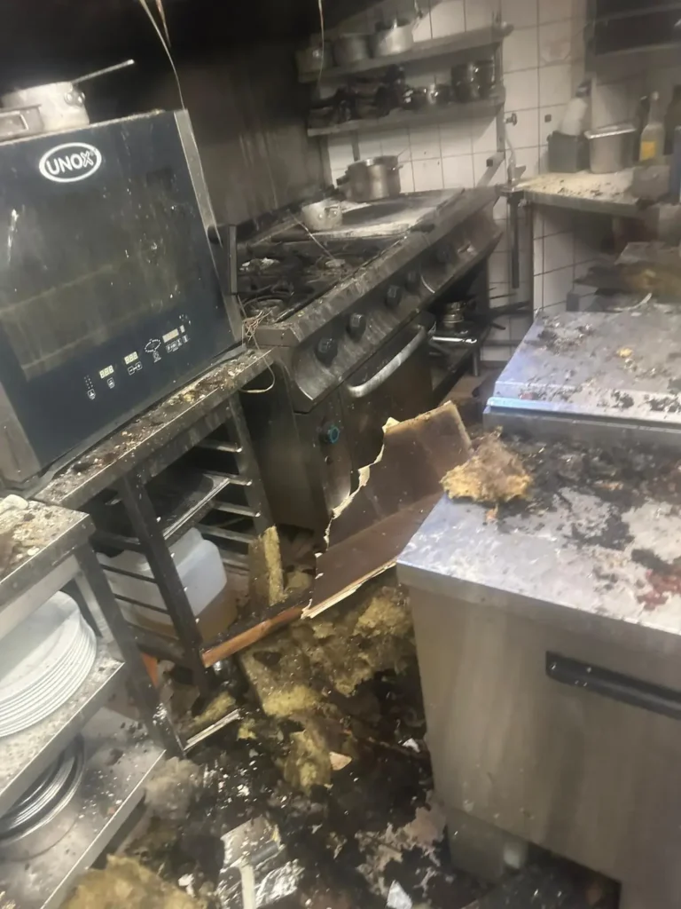 Nettoyage et restauration après incendie - Coplaclean France une cuisine sale après incendie avec une cuisinière et un four cassé